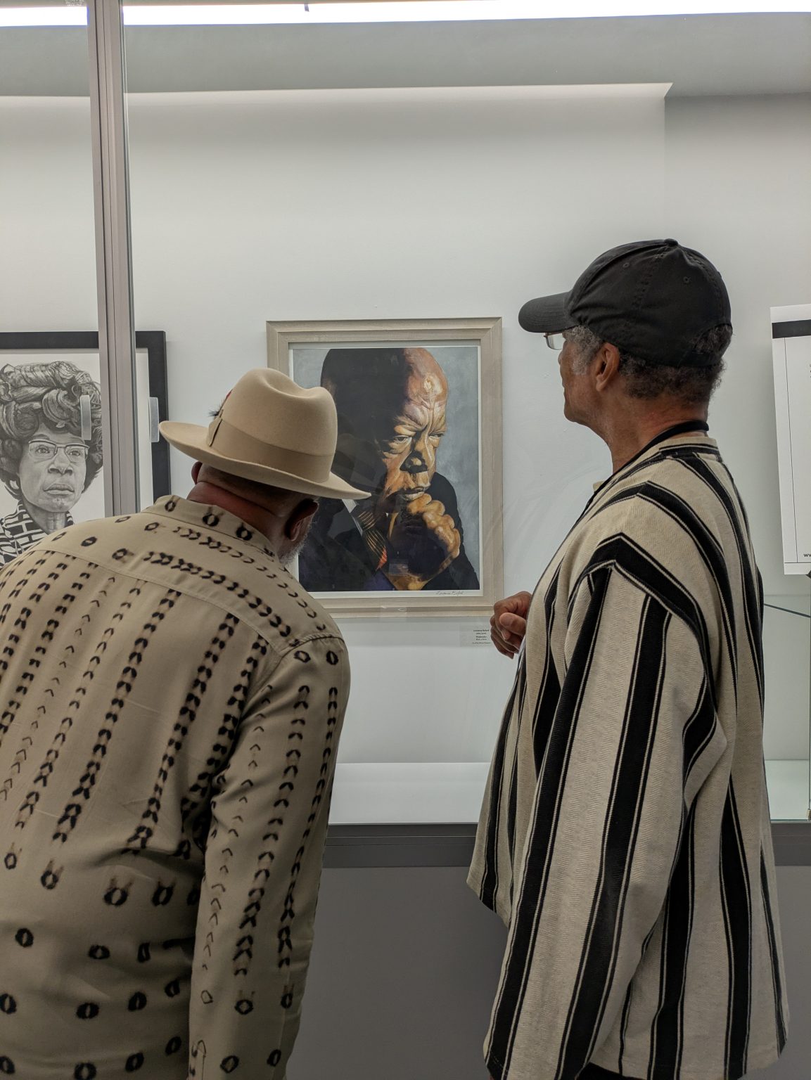 Gallery 3 - Artists Lawrence Buford and Malcom Ryder observing artwork by Lawrence Buford at an Art Passages Exhibit at the County Administration Building in Martinez, CA. Photo by ARTSCCC.