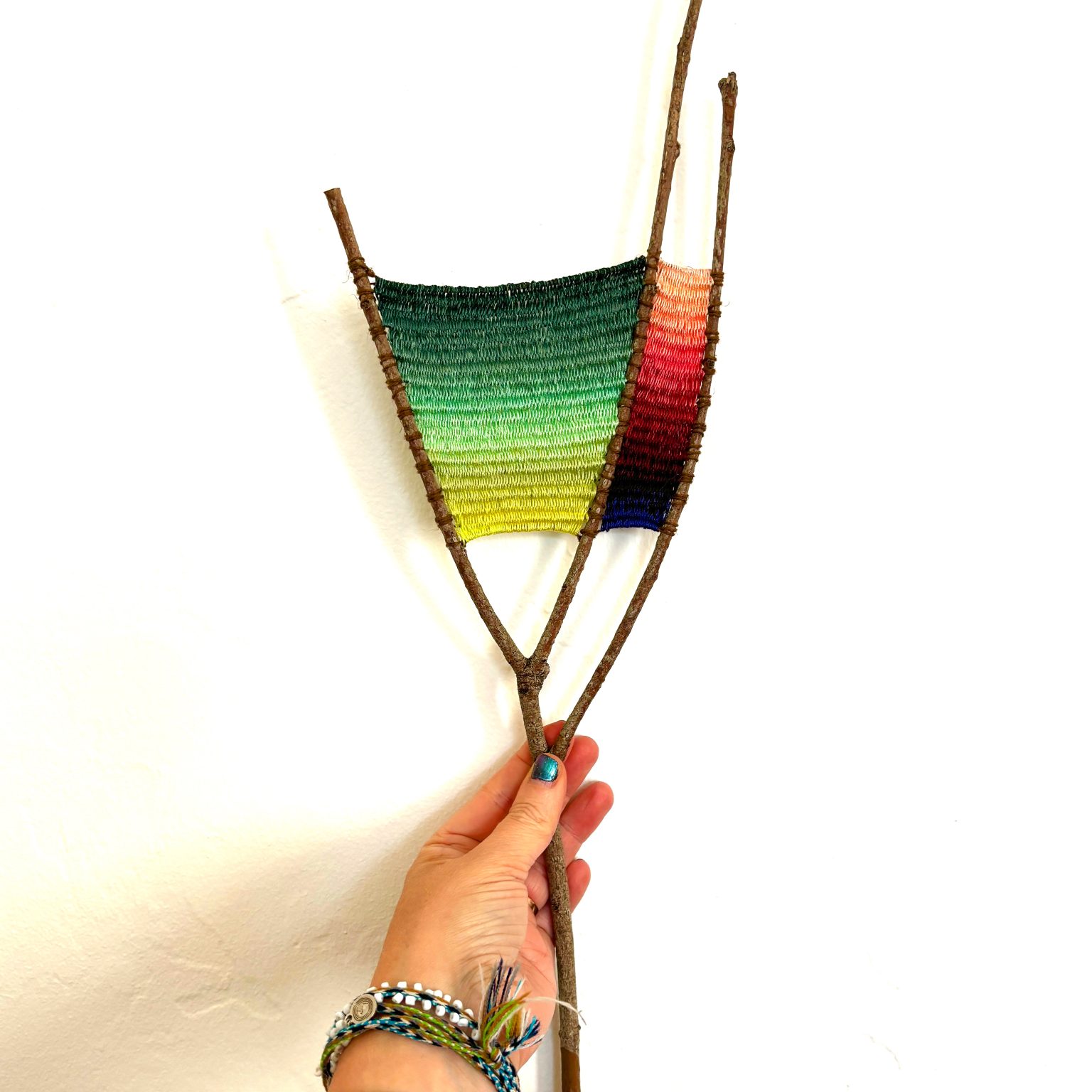 Gallery 1 - this is a tapestry weaving on a branch with ombre pattern.