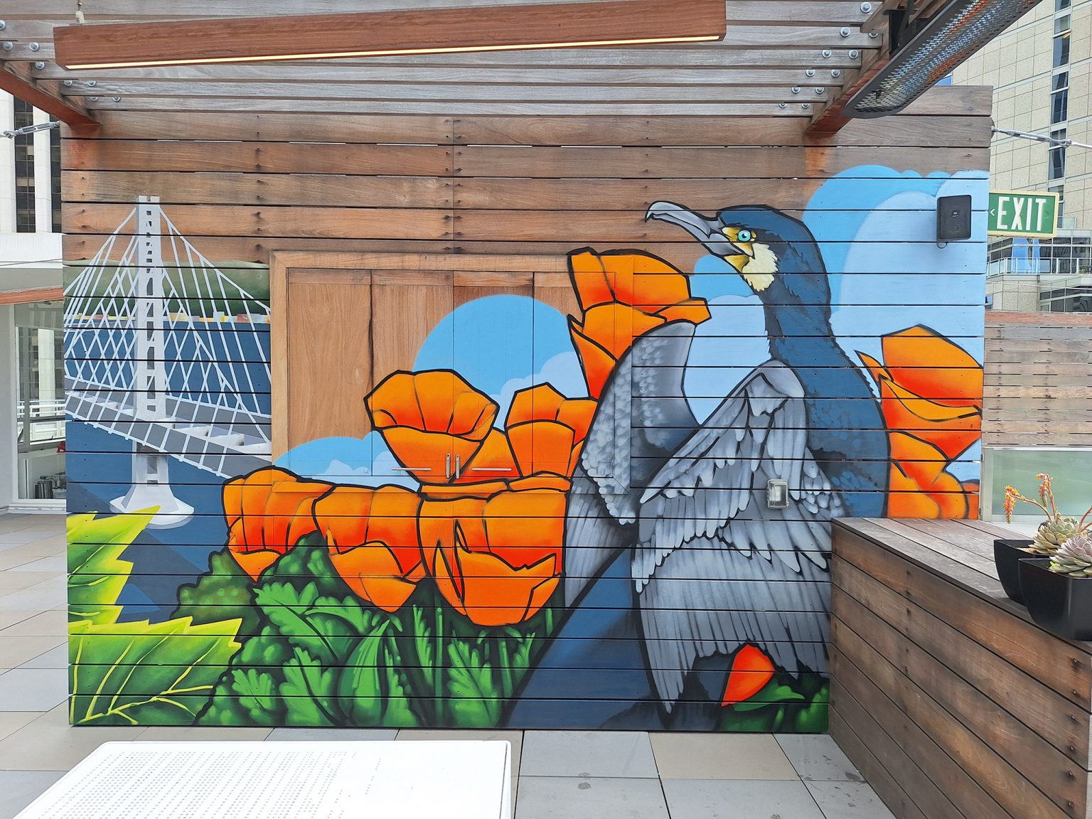 Gallery 2 - Exterior mural with cormorant bird, California poppy flowers and bay bridge.