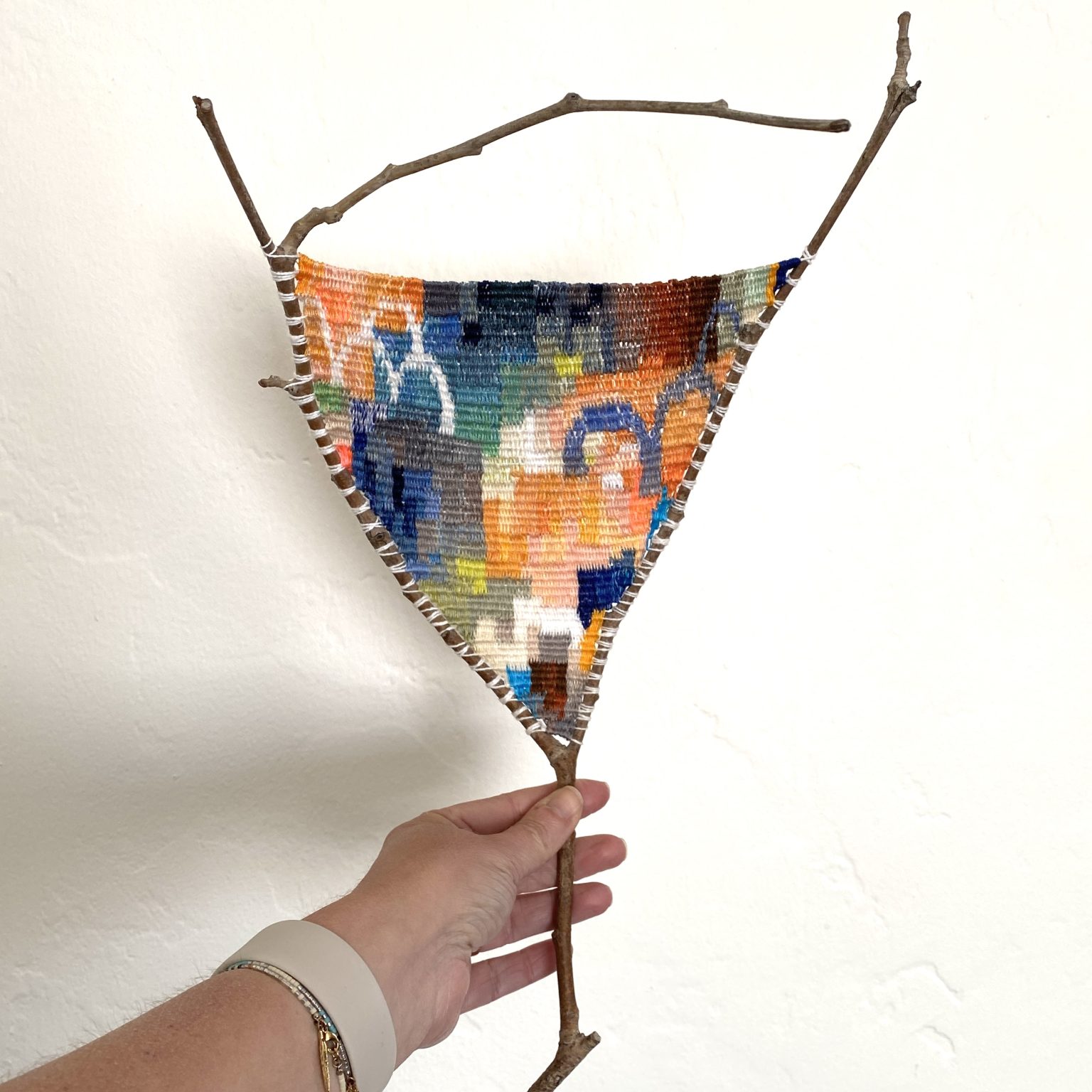 Gallery 3 - this is a tapestry weaving on a branch with abstract pattern.