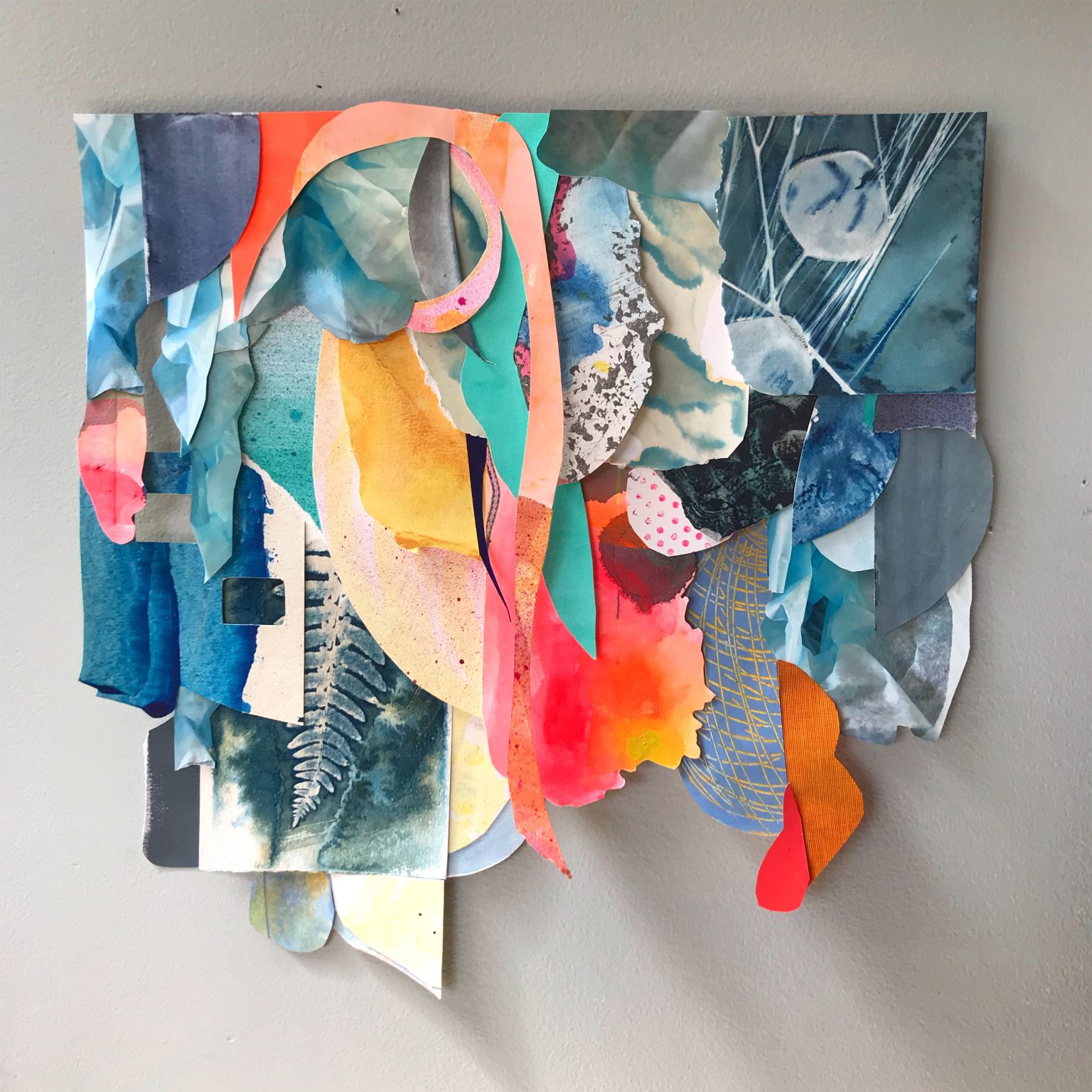 Gallery 3 - A collage of neon orange and gray blue pieces of painted paper attached from a top point 