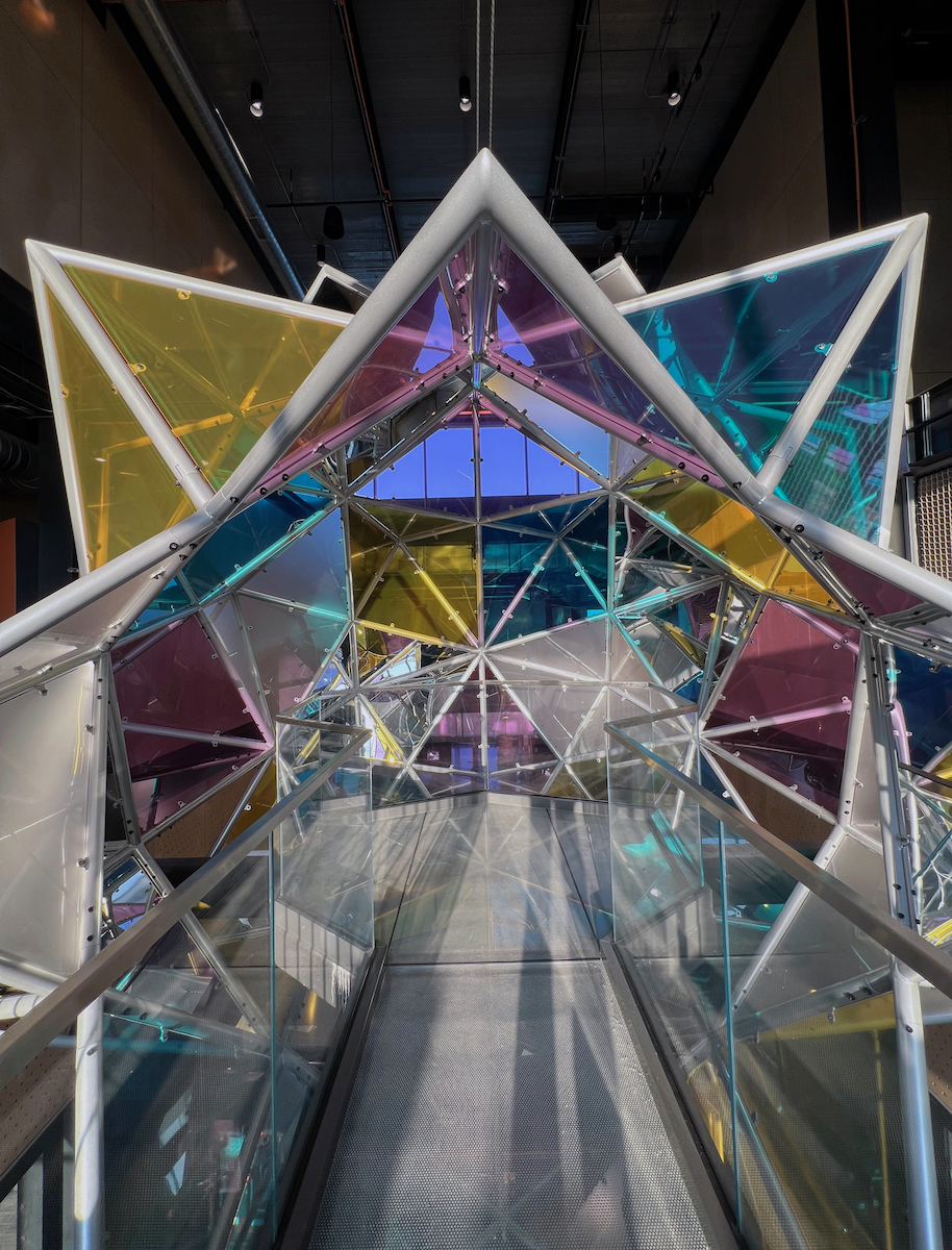 Gallery 4 - Interior view of 20' immersive stellated icosahedron form clad in colored acrylic panels.