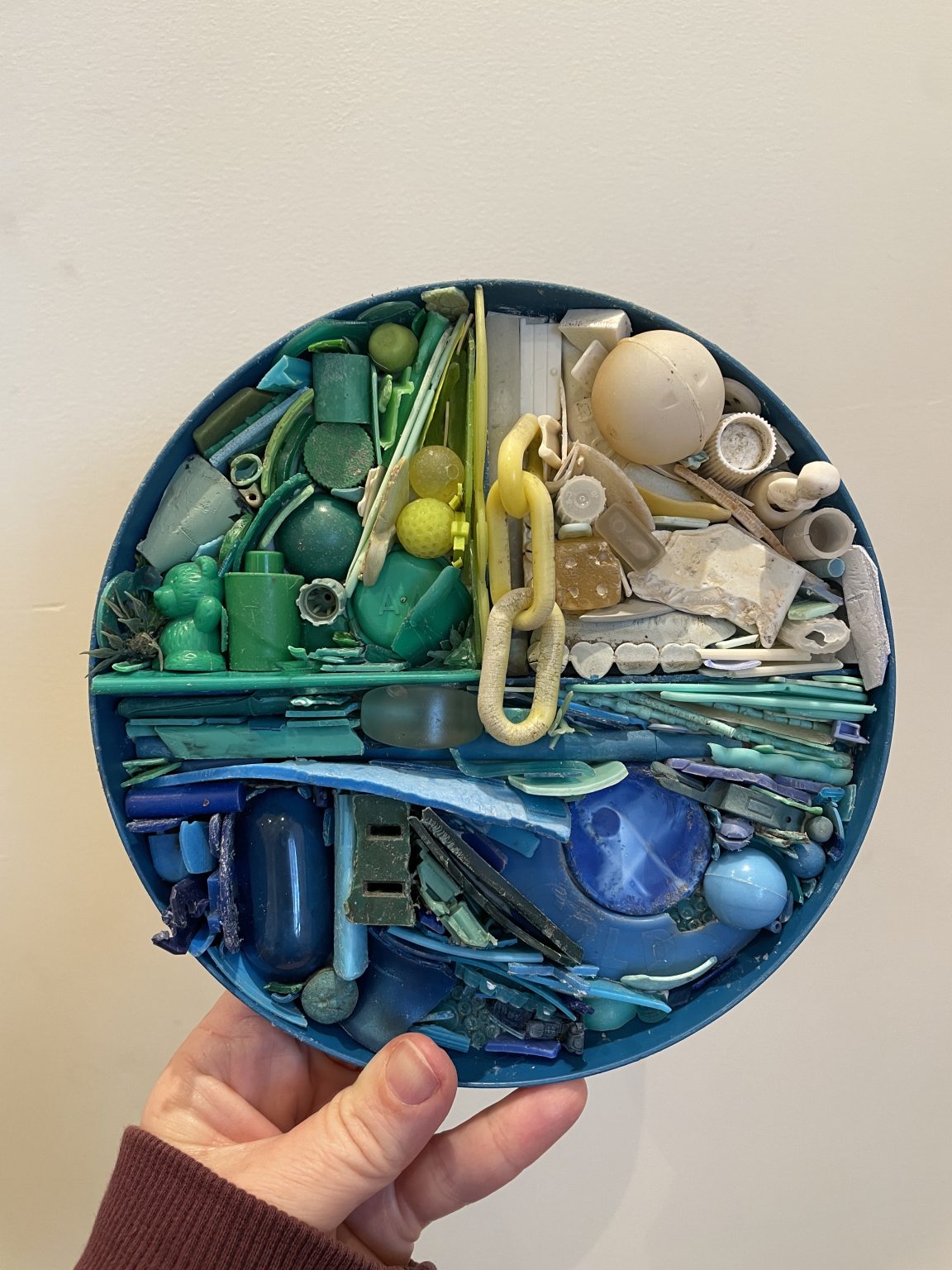 Gallery 6 - A circular mosaic piece made of found plastic in blues, greens, yellows and white