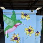 Gallery 2 - A painting of a humming green bird and sun flowers on Utility Box Art