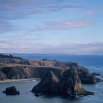 Gallery 6 - image of a shoreline with tall rock islands after sunset or before sunrise