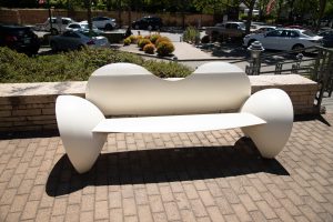 A white metal bench with curvy forms.