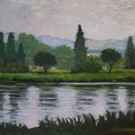 Gallery 4 - Water and reflections. A landscape painting of a lake or river reflecting the shore. The foreground is a body of water with rippling, dark blue and grey reflections of the sky and trees. The closest part of the bank has thick, dark green grass and reeds. The middle ground features a variety of lush green trees, including some tall, thin evergreens and rounder deciduous trees. A grassy green hill and a building are visible behind the trees, with a range of soft, hazy blue-grey mountains in the distance. The sky is a pale, cloudy grey. The artist's visible brushstrokes give the painting a textured, impressionistic feel.