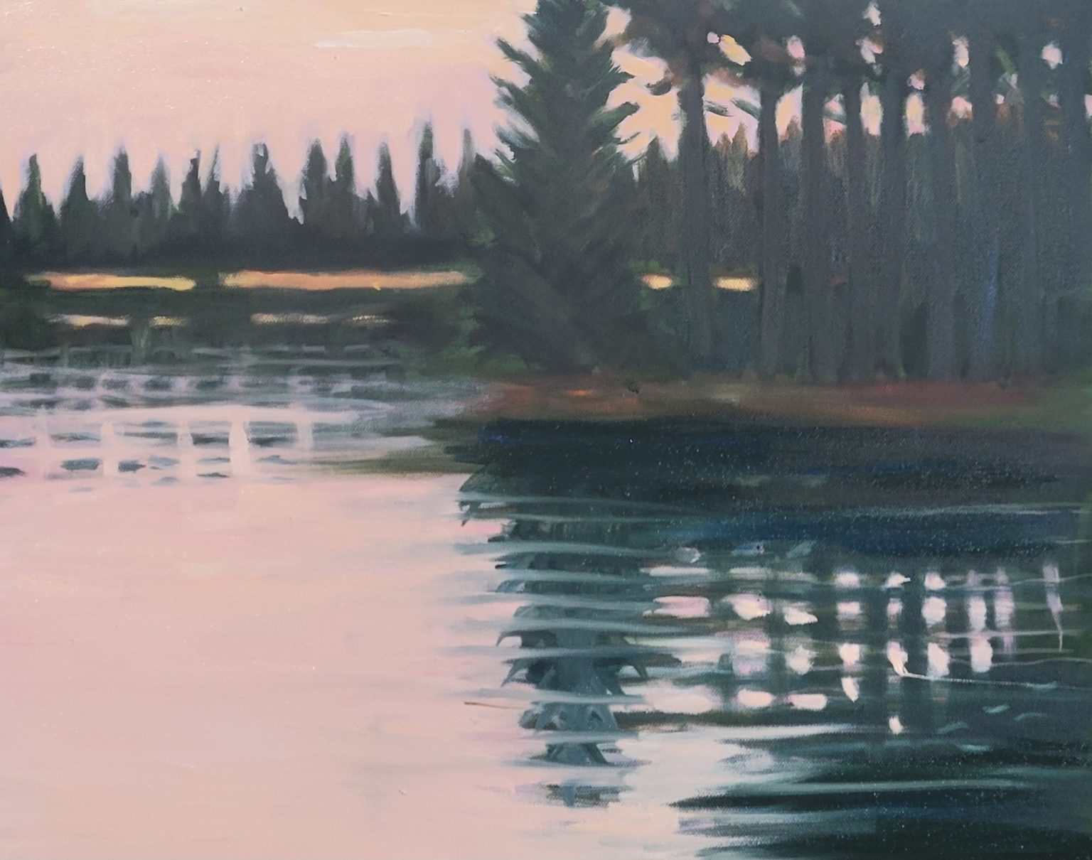 Gallery 6 - Sundown on lake. A horizontal landscape painting of a still lake reflecting a treeline at sunset. The left side of the lake is a soft, pale pink and white, reflecting the hazy sunset sky. The right side is a darker blue and green, reflecting a thick, dark treeline. The treeline is a mix of tall pine trees and shorter bushes, with small patches of bright yellow or orange light visible in the background. The water's surface is full of short, horizontal strokes, giving the impression of soft ripples.