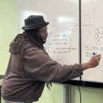 Gallery 2 - Donté Clark writing on a whiteboard during a “Poetry Series Program” workshop at Juvenile Hall in Martinez.