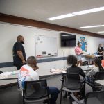Gallery 2 - Tajanique Bell and Jeremy Phillip speaking in front of students at a “Youth Arts Connection” workshop at the Antioch Library.