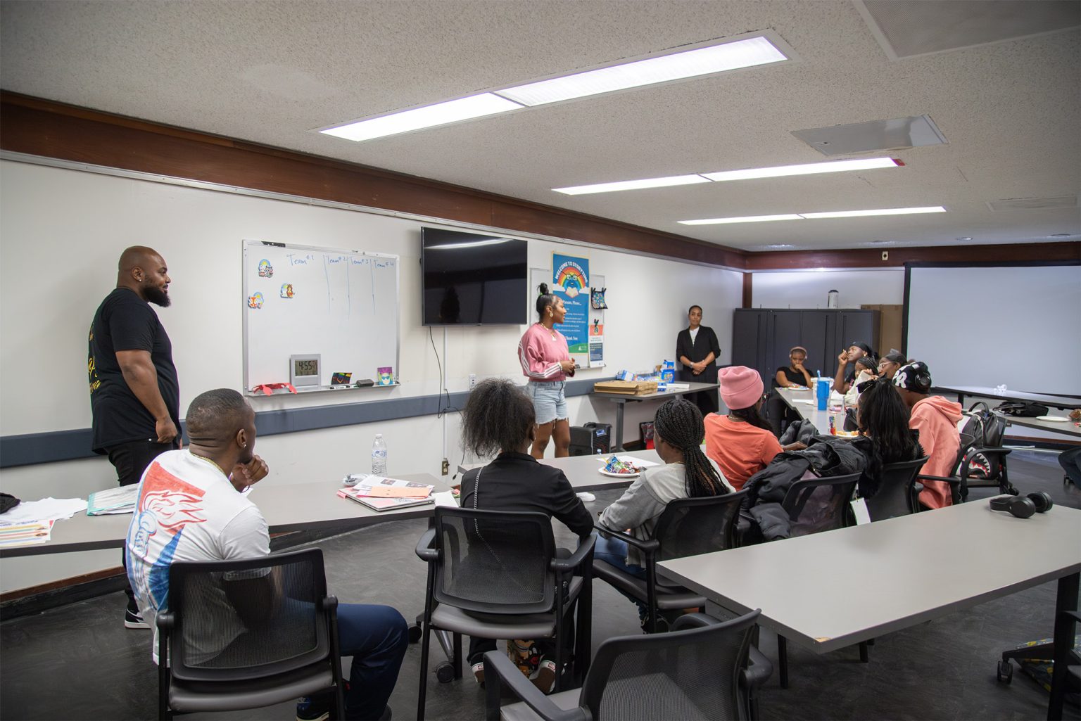 Gallery 2 - Tajanique Bell and Jeremy Phillip speaking in front of students at a “Youth Arts Connection” workshop at the Antioch Library.