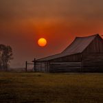 Gallery 10 - Picture of the iconic T.A. Moulton Barn in Grand Teton NP with the sun rising through thick smoke.
