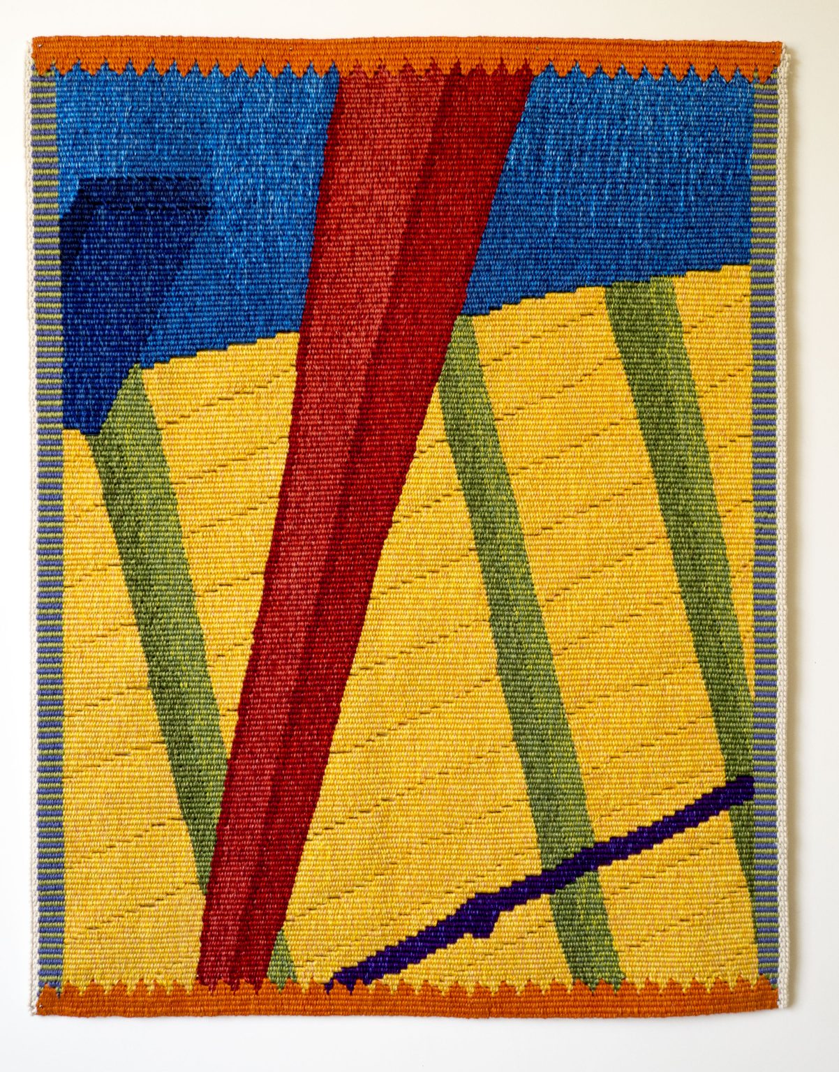 Gallery 3 - A brightly colored handwoven tapestry with diagonal geometric shapes.
