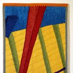 Gallery 3 - A brightly colored handwoven tapestry with diagonal geometric shapes.