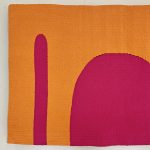 Gallery 7 - An orange and pink abstract handwoven tapestry with a large half circle and longer linear shape.