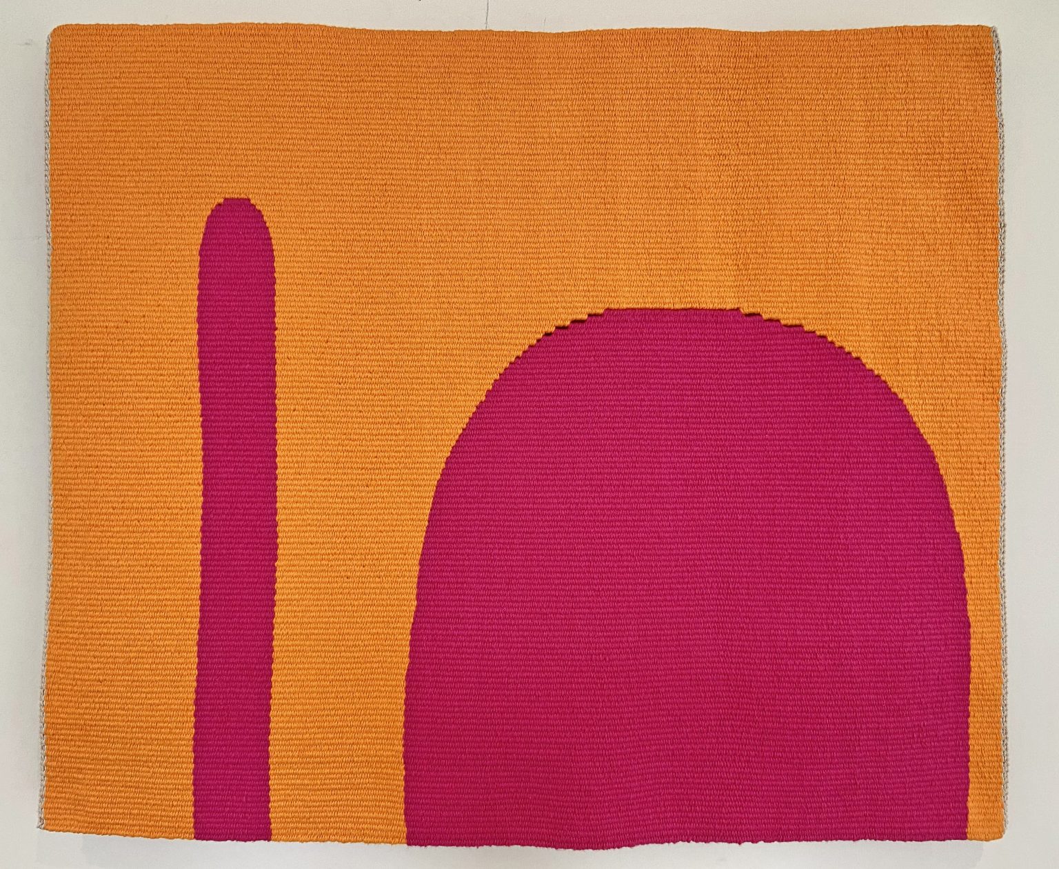 Gallery 7 - An orange and pink abstract handwoven tapestry with a large half circle and longer linear shape.