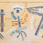 Gallery 6 - Close up of a large, colorful abstract mosaic tile mural on the beige brick wall of a building at Contra Costa College. The artwork features stylized, interconnected symbols in blue, red, orange, and white, suggesting themes of science, nature, and evolution. A grassy lawn and a road are in the foreground, with trees and hills in the background.