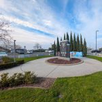 Gallery 3 - A wide outdoor mural on a low concrete wall depicting six military service members in various uniforms, including a veteran in a saluting pose. The center includes the message 