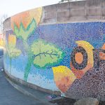 Gallery 4 - A colorful mosaic mural on a curved concrete wall displays the word 