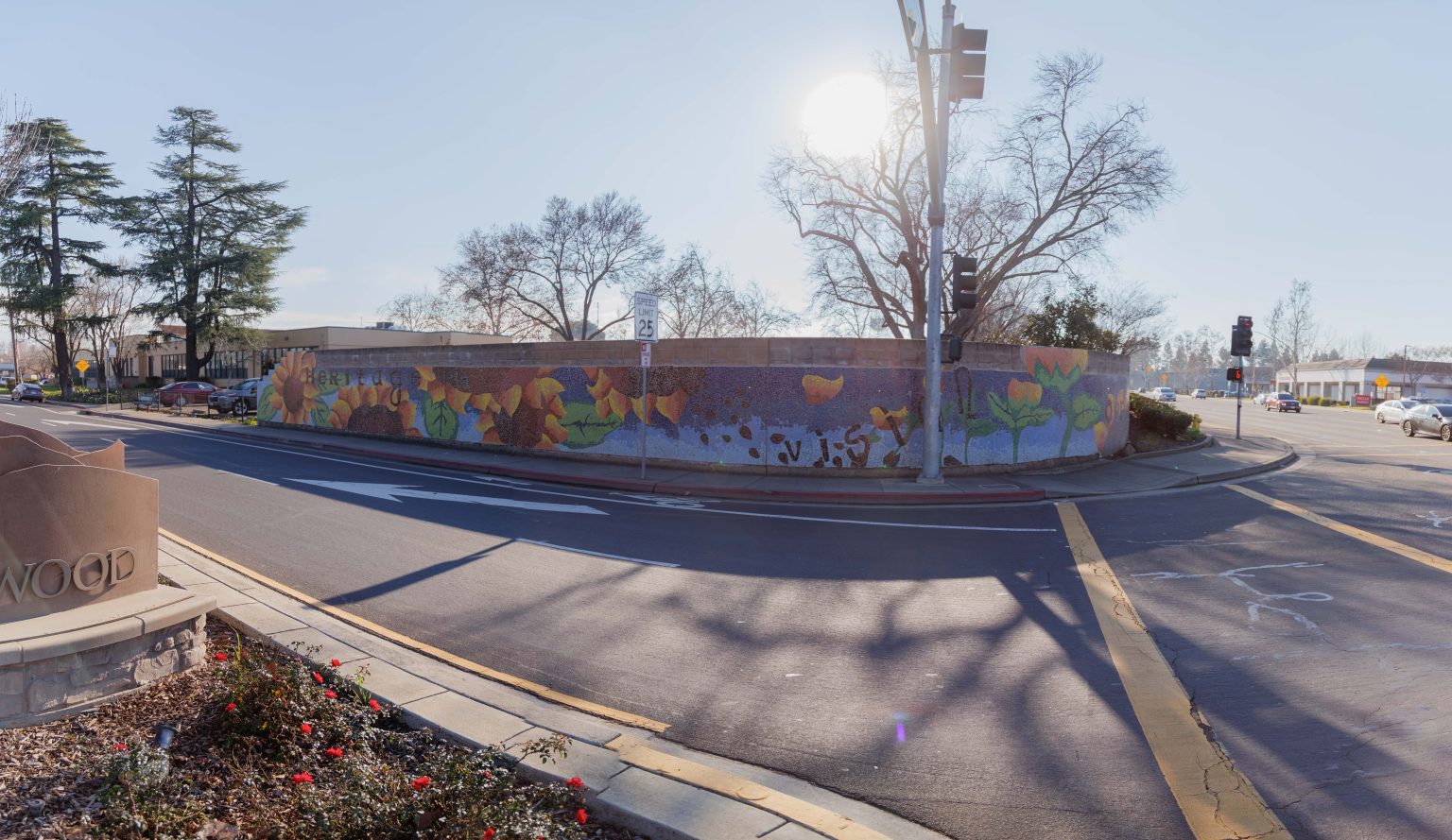 Gallery 3 - A colorful mosaic mural on a curved concrete wall displays the word 