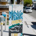 Gallery 2 - A series of three utility boxes painted with colorful murals. One box shows a classic black car with 
