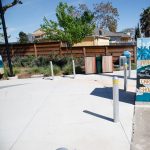 Gallery 3 - A series of three utility boxes painted with colorful murals. One box shows a classic black car with 