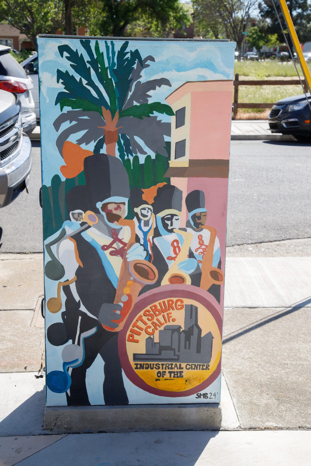 Gallery 4 - A series of three utility boxes painted with colorful murals. One box shows a classic black car with 