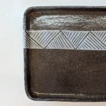 Gallery 2 - Rectangular platter made from dark clay, with a white carved stripe across the top