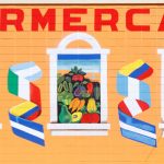Gallery 2 - Alt Text: A painted mural on an orange cinder block wall displays the word 