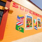 Gallery 3 - A painted mural on an orange cinder block wall displays the word 